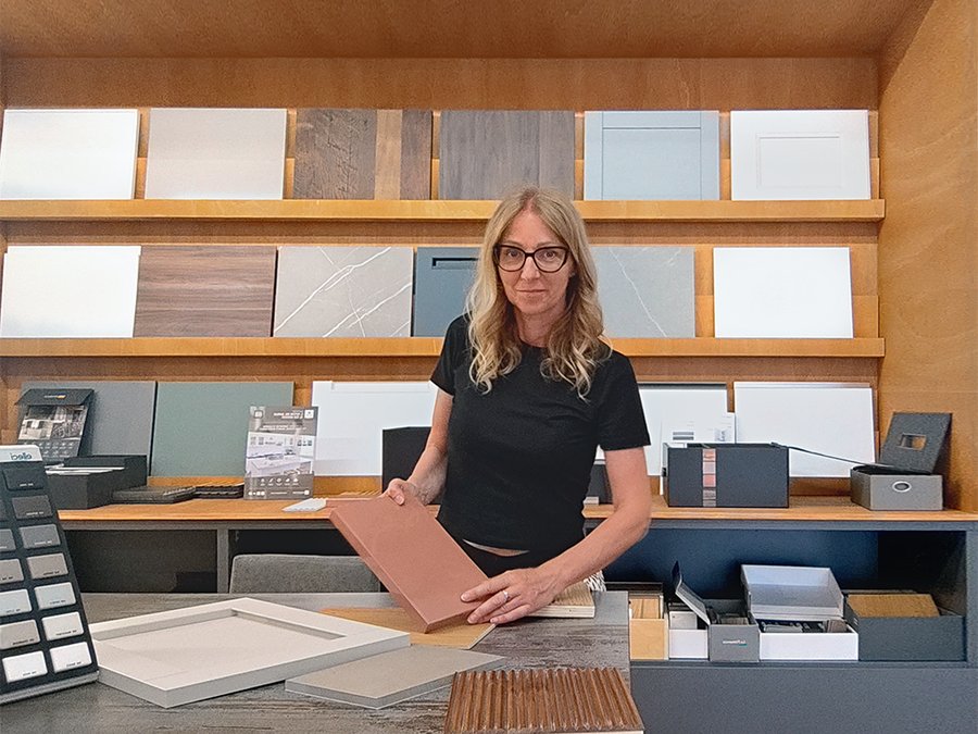 Emanuela di Ruffato Arredamenti in showroom, mentre sceglie fra i campioni di materiali esposti sugli scaffali